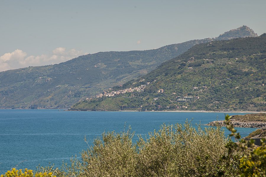 Coastal town on a green hillside above blue water