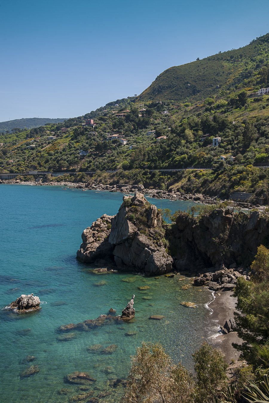 Rocky coast and green hillside in Cefalù